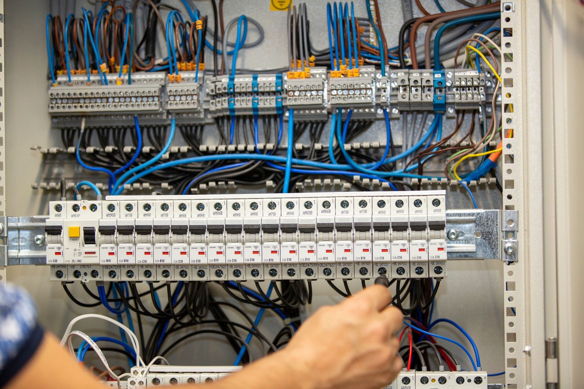 Electrician working at electric panel